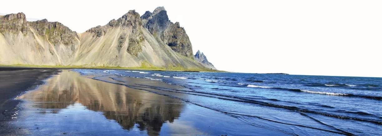 Vestrahorn mountain reflected on a black sand beach in Iceland